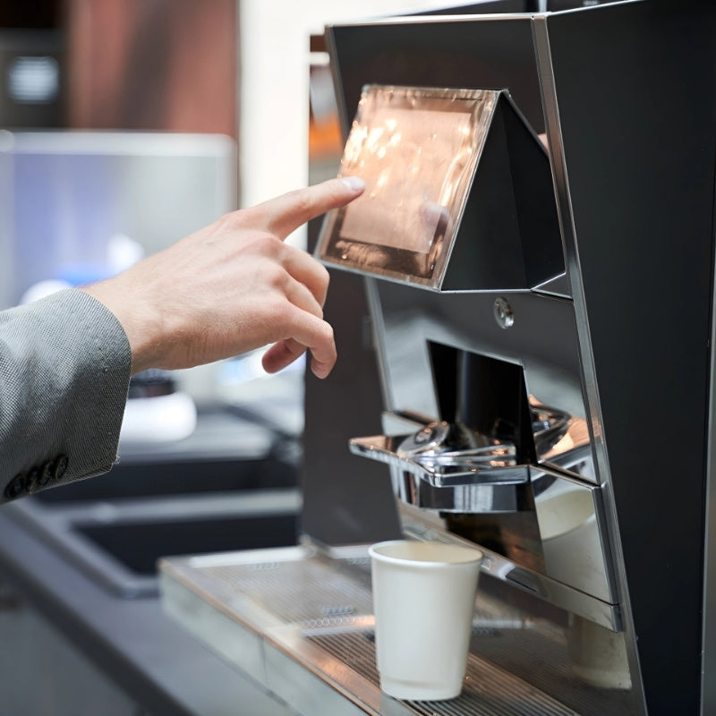 side view of someone pressing for a drink on an instant coffee machine